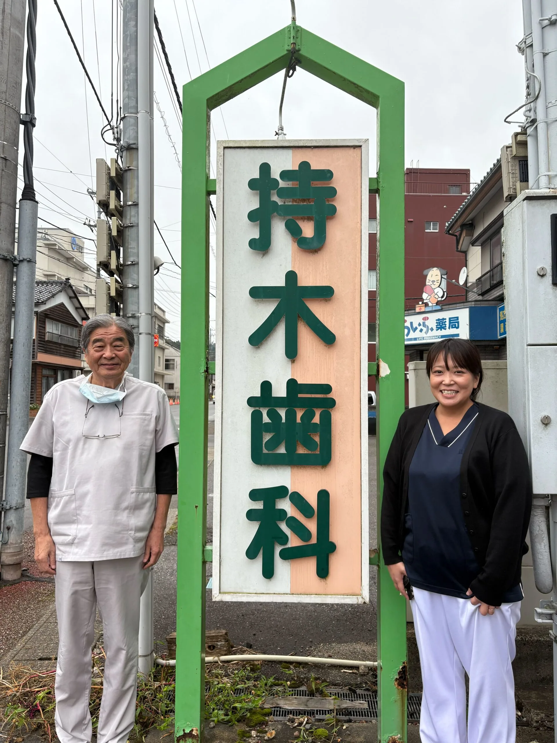 インタビューの終わりに。持木歯科医院の看板の前で。